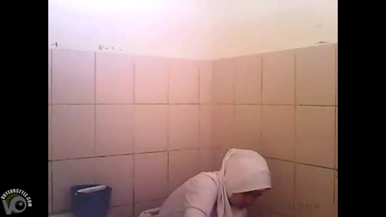Arab woman goes pee in a public toilet