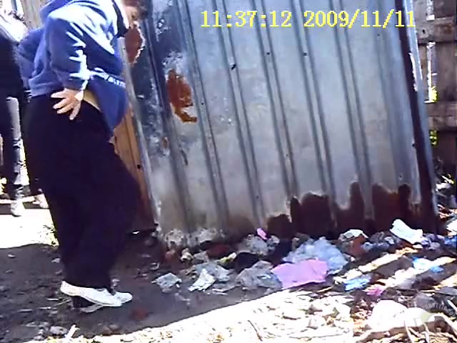 Public urinating in the dirt and garbage