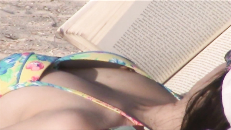 Sexy brunette sunbathes her body on the beach