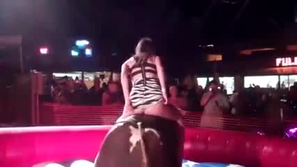 Mechanical bull riding hottie flashes her panties