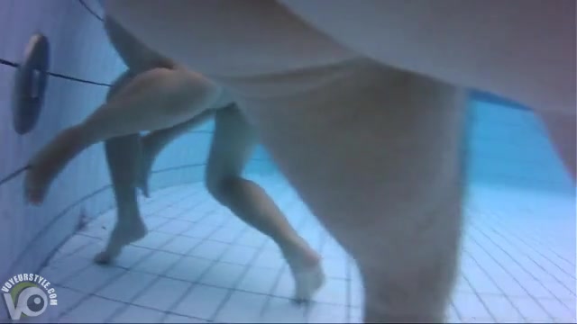 Naked women underwater at a nudist resort pool