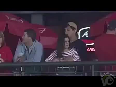 Fondling his cute girlfriend at a baseball game