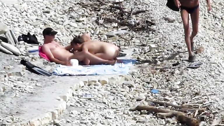 Sensual girl jumps on her boyfriend's fat dick at the nude beach