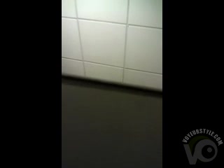 Spying over the bathroom stall on a peeing girl