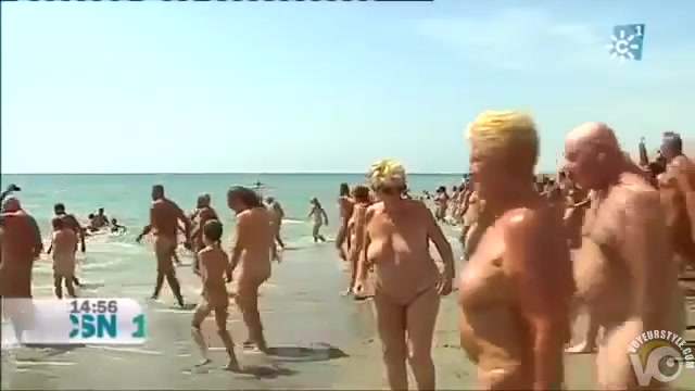 Mature Spanish nudists walk around the beach completely naked