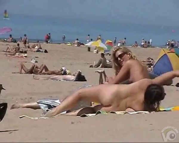 Sunny day at the public beach with two nudist girls