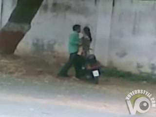 Pakistani couple bangs on a moped by the side of the road