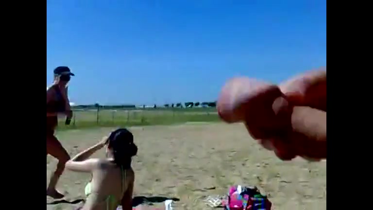 Ejaculating on a topless woman on the beach