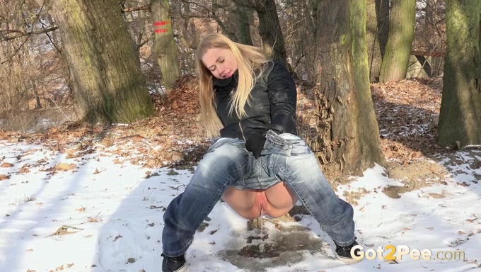 Blonde amateur cute girl outside on a winter day pisses on the snow