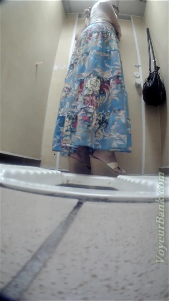 Lovely lady in summer dress pisses in the toilet restroom