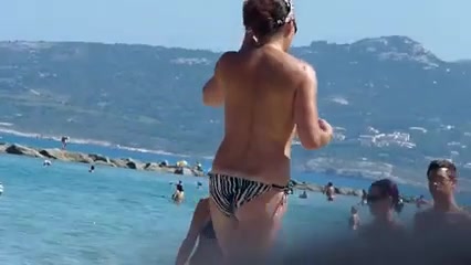 Hidden cam video with a topless brunette sunbathing on a beach